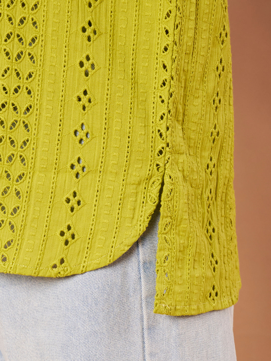 Detail of schiffli embroidery on lime green cotton shirt fabric