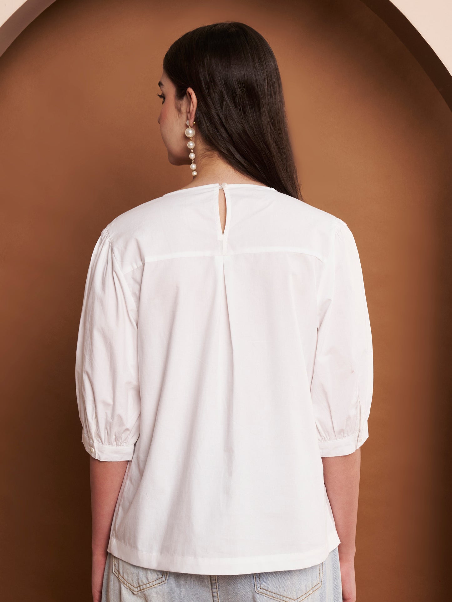 Close-up of pleated cotton fabric on white puff sleeve top