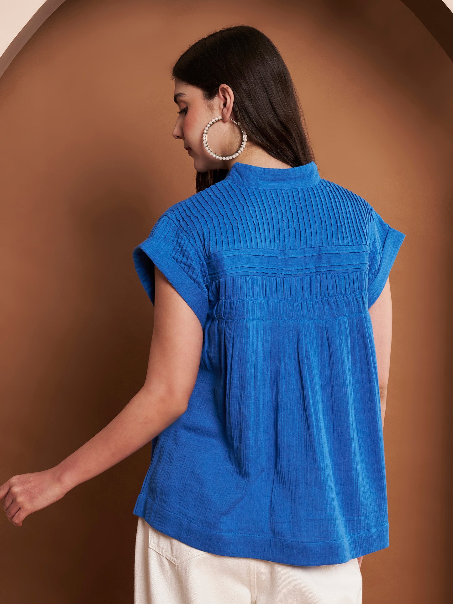 Back view of navy blue pleated cotton top with mandarin neckline